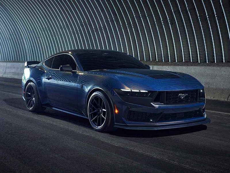 A dark blue Ford Mustang Dark Horse sports car driving through a tunnel